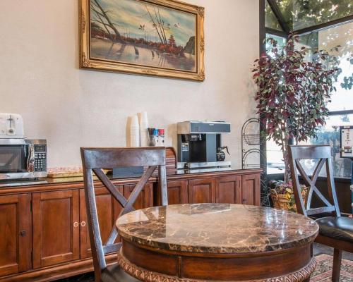a kitchen with a table and two chairs and a coffee maker at Palm Inn Hotel near Tyler Mall Riverside in Riverside