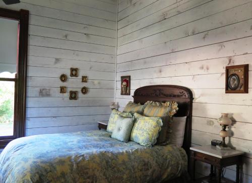 um quarto com uma cama e uma parede de madeira em Yellow House B&B em Salado