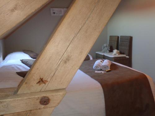 um quarto com uma cama com uma estrutura em madeira em hoevehotel ter haeghe em Gistel
