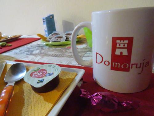 a coffee cup sitting on a table next to a spoon at Domoruja B&B in Sassari