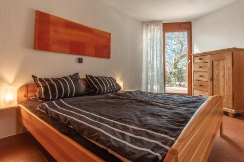 Schlafzimmer mit einem Bett mit einem Holzrahmen und einem Fenster in der Unterkunft FeWo Litzendorf in Litzendorf