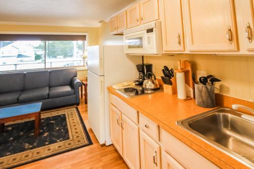 a small kitchen with a sink and a refrigerator at InnSeason Resorts Captain's Quarters in Falmouth