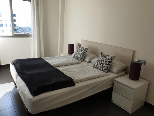 a bed with a black blanket on it in a bedroom at La Manga Paradies zwischen den zwei Meeren in La Manga del Mar Menor