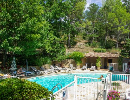 une grande piscine entourée d'une clôture blanche. dans l'établissement Villa Borghese, The Originals Relais, à Gréoux-les-Bains