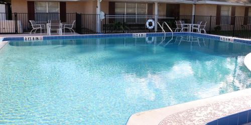 a large swimming pool with chairs in a hotel at Magic Key - Near Disney in Kissimmee