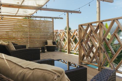 una terraza con sillas y una valla de madera en Cliff's Hostel, en La Gruta