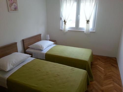 - 2 lits dans une chambre avec fenêtre dans l'établissement Apartment Branko-with parking, à Vinišće