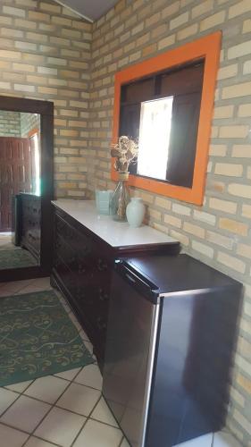 a kitchen with a counter with a window and a mirror at Chales Jack & Jill in Pipa