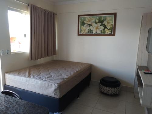 um quarto com uma cama e um quadro na parede em Park L'acqua di roma - Cozinha completa em Caldas Novas