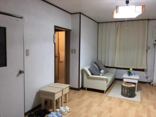 a living room with a couch and a table at Happy Apartment in Sapporo