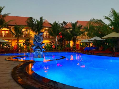 a swimming pool with a fountain in front of a resort at Golden Topaz Phu Quoc Resort in Phu Quoc