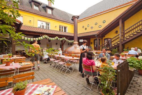 a group of people sitting at tables in a restaurant at Hotel Gasthof Post in Nesselwang