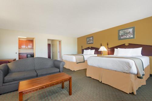 a hotel room with two beds and a couch at Days Inn by Wyndham Norton in Norton