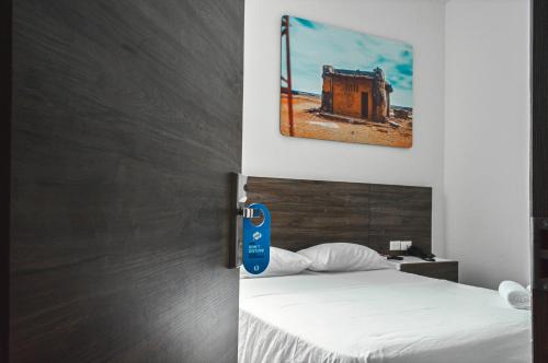 een slaapkamer met een bed met een blauwe sleutel bij Hostel Laguna Salá By FSL in Ríohacha