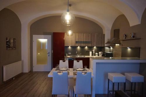 a kitchen with a dining table and chairs and a kitchen with at Gästehaus Familie Löffler - Ferienwohnung am Stadtplatz in Litschau in Litschau