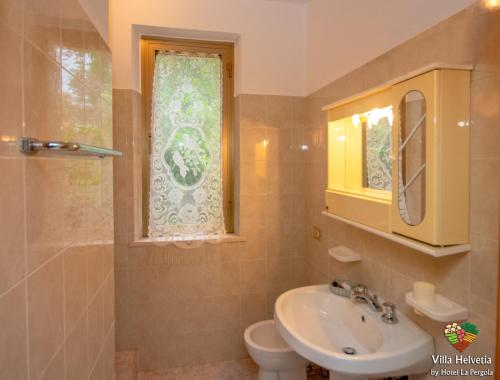 une salle de bain avec un lavabo et des toilettes et une fenêtre dans l'établissement Villa Helvetia, à Corropoli