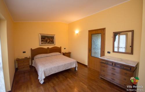 une chambre avec un lit, une commode et un miroir dans l'établissement Villa Helvetia, à Corropoli