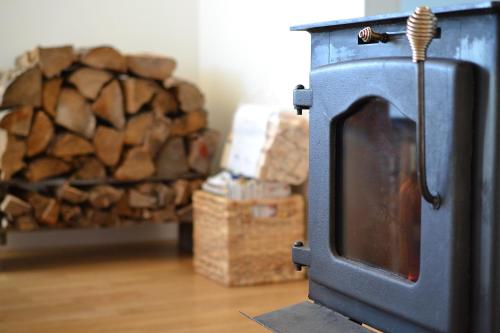 a stove in a room with a pile of logs at Les 4 chalets - Le 605 in Lac-Saint-Paul