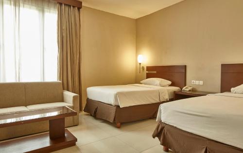 Postel nebo postele na pokoji v ubytování Triniti Hotel Jakarta