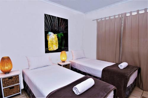 a hotel room with two beds and a window at Sanctuary Lake Apartments in Gold Coast