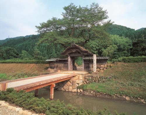 a wooden bridge over a river in a field at Dormy Inn Premium Fukui Natural Hot Spring in Fukui