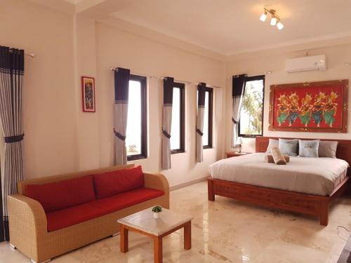a bedroom with a bed and a couch at Medewi Manor in Pulukan