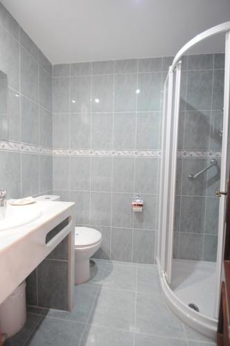 a bathroom with a shower and a toilet and a sink at Hotel Goya in Almuñécar