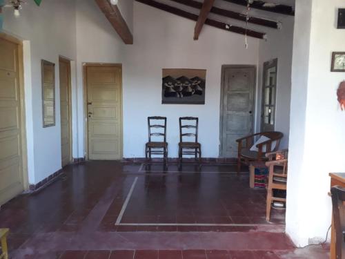 a living room with two chairs and a table at Habitación en Casa Las Dos Nenas in Río Ceballos
