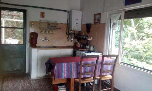 a kitchen with a table and two chairs and a stove at Habitación en Casa Las Dos Nenas in Río Ceballos