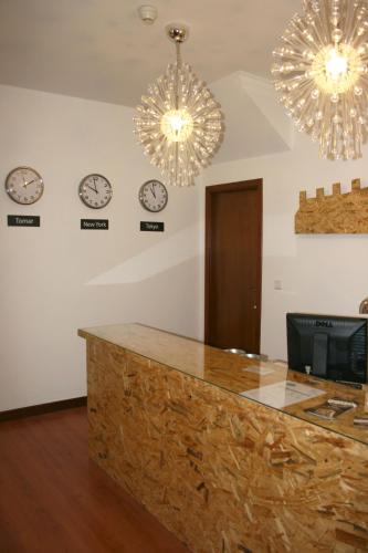 a room with clocks on the wall and a counter at Hostel 2300 Thomar in Tomar