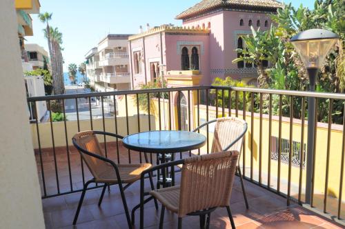 a patio with a table and chairs on a balcony at Hotel Goya in Almuñécar