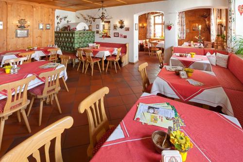 a restaurant with tables and chairs with red tablecloths at Hotel Gasthof Post in Nesselwang