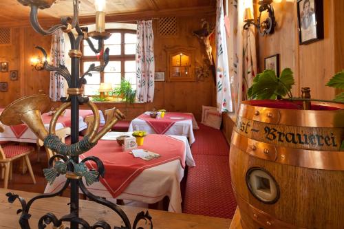 a restaurant with two tables and a wine barrel at Hotel Gasthof Post in Nesselwang