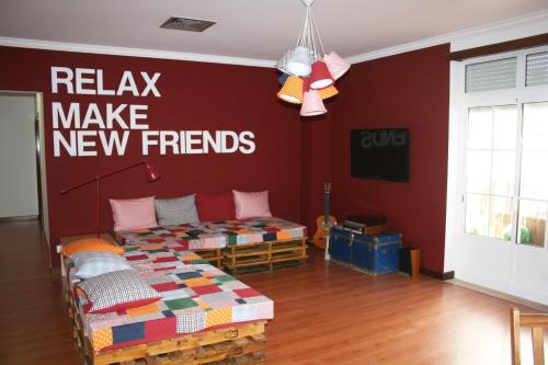 a room with a bed and a sign that says relax make new friends at Hostel 2300 Thomar in Tomar