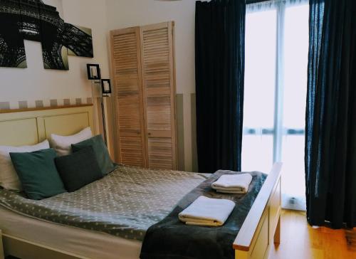 ein Schlafzimmer mit einem Bett mit zwei Handtüchern darauf in der Unterkunft Przytulna Kawalerka w Kamienicy in Olsztyn