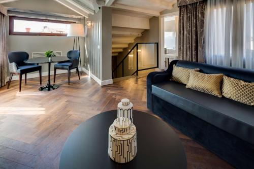 a living room with a blue couch and a table at BW Premier Collection CHC Continental in Venice