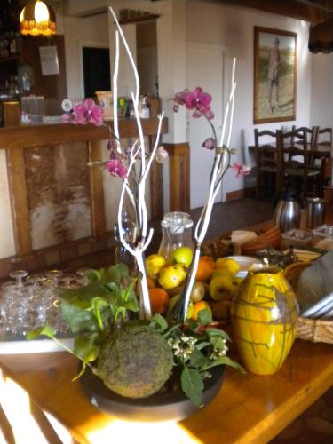 une table avec un bouquet de fruits et de légumes dans l'établissement Hôtel La Randonnée, à Nasbinals