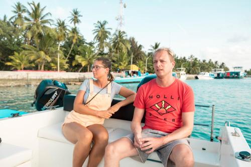 a man and woman sitting on a boat in the water at Athiriveli in Thoddoo