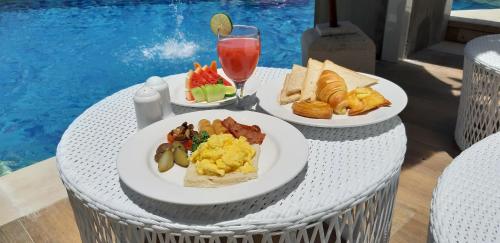 two plates of breakfast food on a wicker table at 18 Suite Villa Loft at Kuta in Kuta