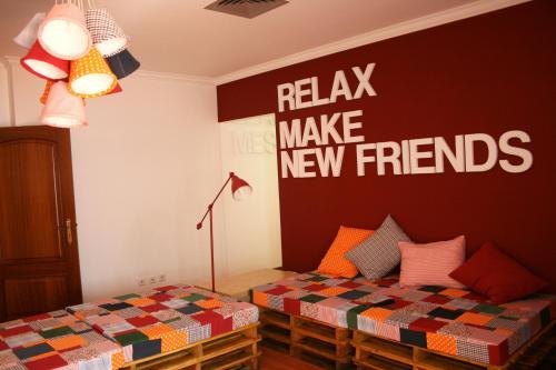 een slaapkamer met een bed en een bord dat zegt relax maak nieuwe vrienden bij Hostel 2300 Thomar in Tomar