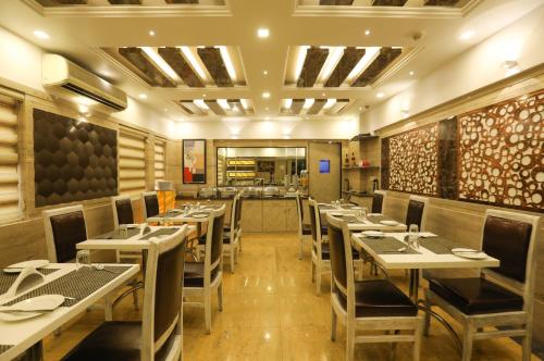 a restaurant with tables and chairs in a room at Jyoti Dwelling Hotel in Mumbai