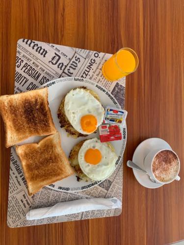 a plate with eggs and toast and a cup of coffee at Holiday Home Patong in Patong Beach