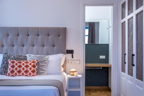a bedroom with a large bed and a mirror at Shapes Luxury Suites in Ermoupoli