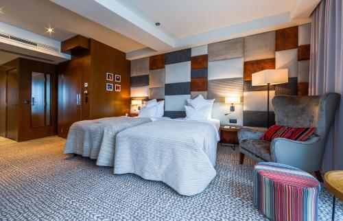 a hotel room with a bed and a chair at Grand Hotel Boutique in Rzeszów