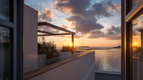 a view of the sunset from a balcony of a house at Shapes Luxury Suites in Ermoupoli
