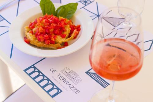 a bowl of food and a glass of wine on a table at Albergo Palazzo in Santa Cesarea Terme