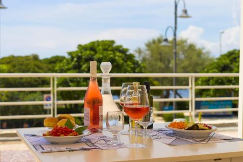 a table with a glass of wine and bowls of food at Albergo Palazzo in Santa Cesarea Terme