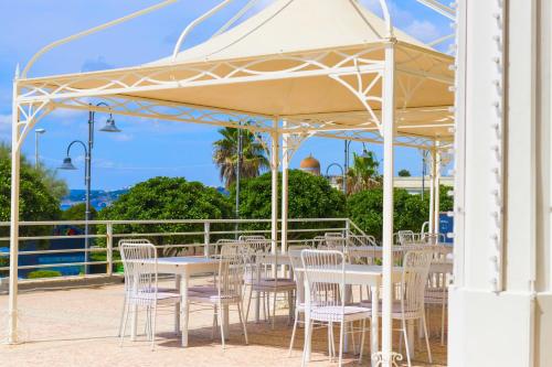 a white tent with tables and chairs under it at Albergo Palazzo in Santa Cesarea Terme
