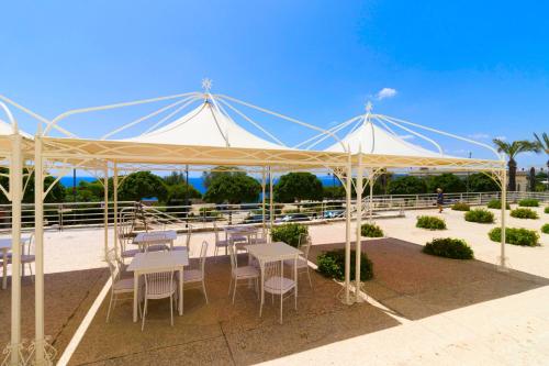 a white tent with tables and chairs under it at Albergo Palazzo in Santa Cesarea Terme