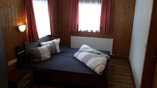 Bett in einem Zimmer mit zwei Kissen darauf in der Unterkunft Ferienhaus Eiter in Sankt Leonhard im Pitztal